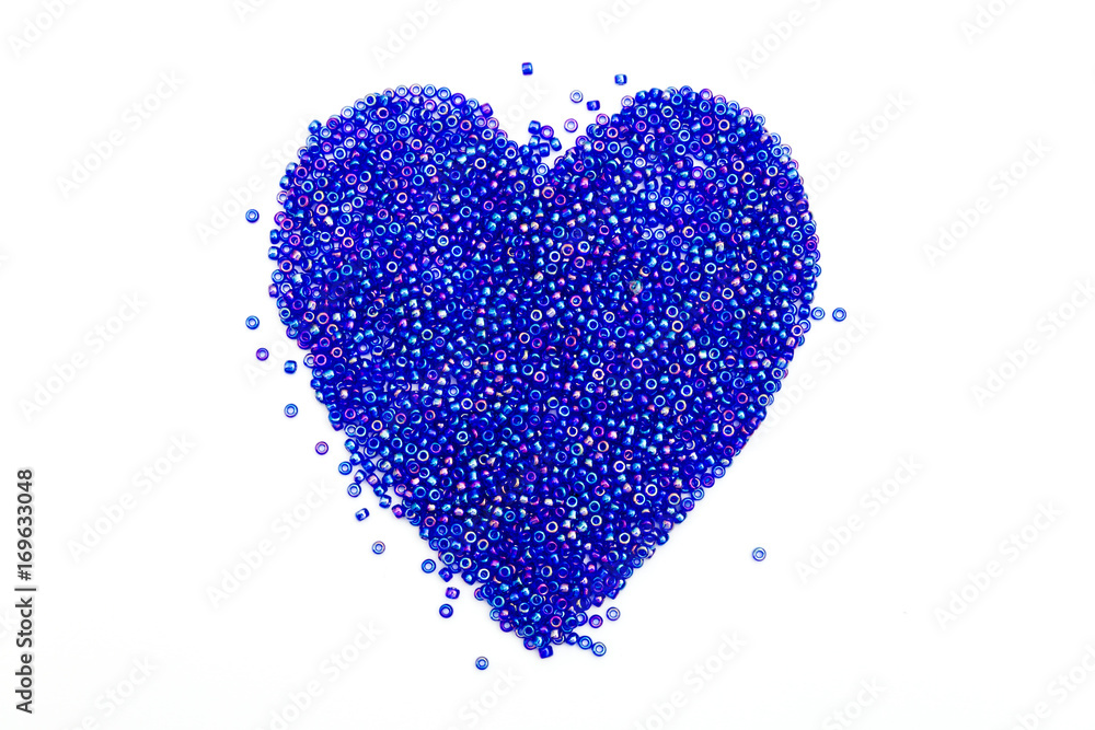 Tiny shiny beads in shape of heart on white background