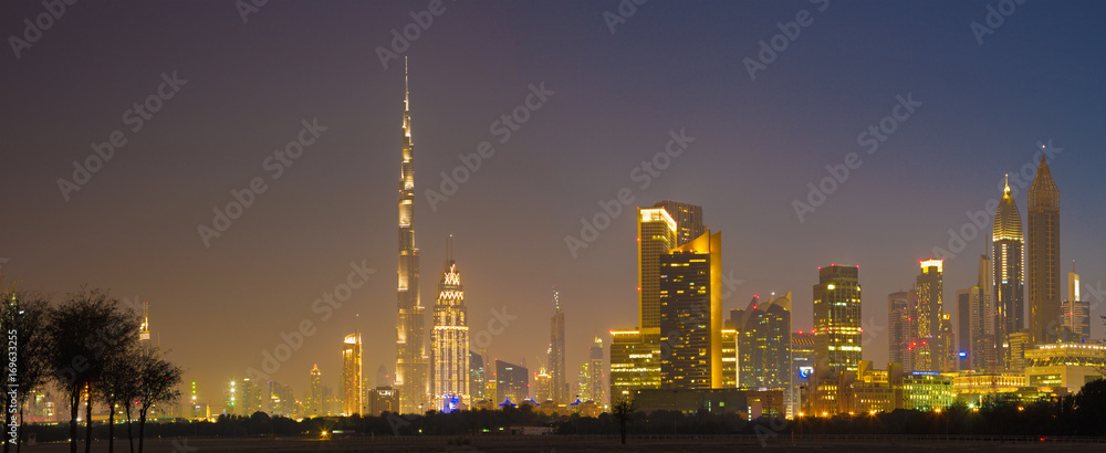 Dubai - The evening skyline of Downtown with the Burj Khalifa and Emirates Towers.