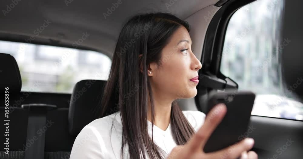 Businesswoman in taxi cab using smartphone Businesswoman in taxi cab using smartphone