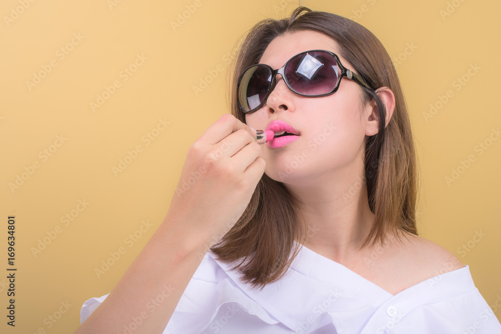 Beautiful woman using a lipstick Beautiful woman using a lipstick