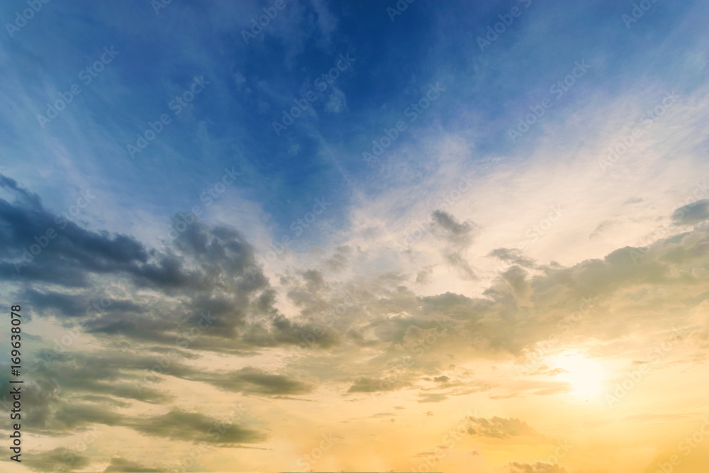 Obraz premium Sky background at sunset,Sky blue and orange light of the sun through the clouds in the sky survive
