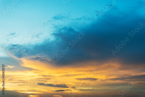 Sky background at sunset,Sky blue and orange light of the sun through the clouds in the sky survive