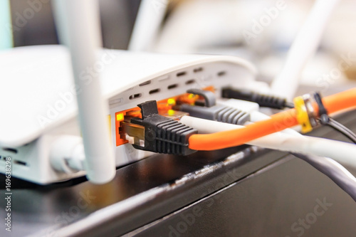 Closeup of Wi-Fi wireless router with cables and wan port in conference room, communication technology background photo