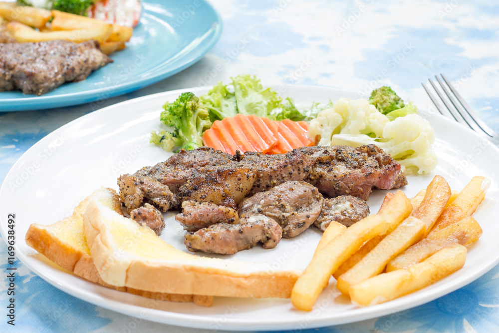 Grilled steak with french fries and vegetables and toast