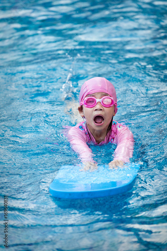 Little girl learning in a swimming pool.