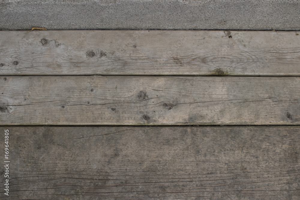 Wood planks with a strip of concrete at the top Wood planks with a strip of concrete at the top