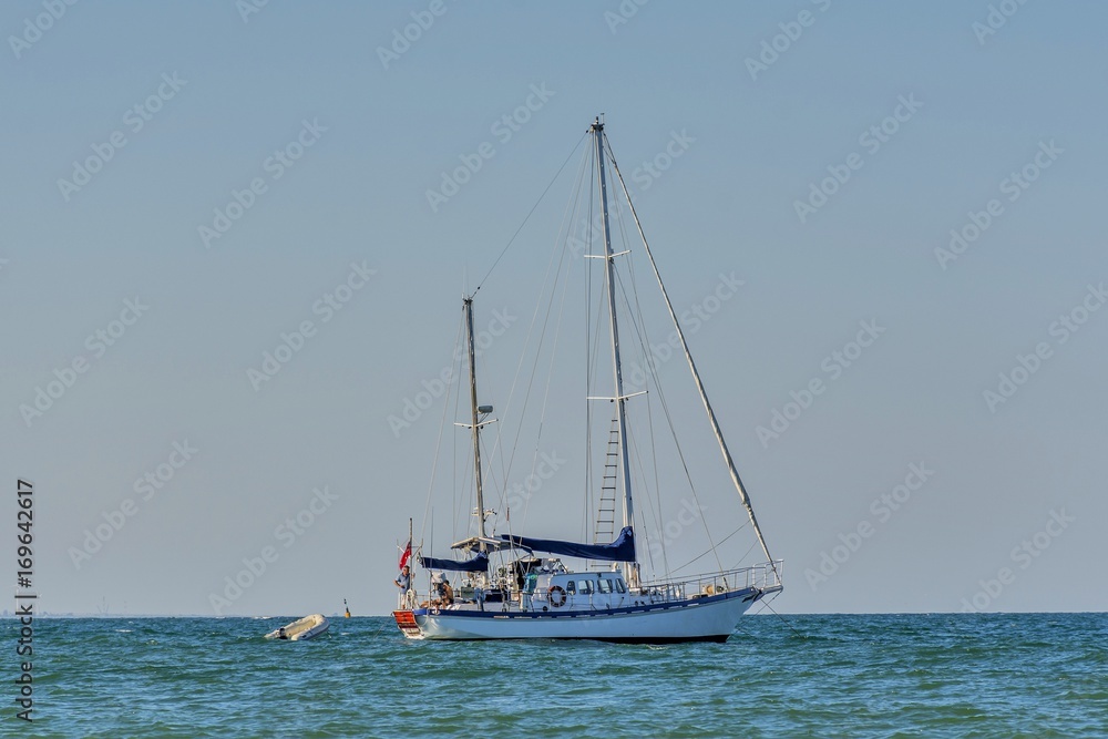 Classic white yachts anchored in the port .  Sailing a classic yacht on the Black Sea.Vintage sailboat anchored in turquoise water .