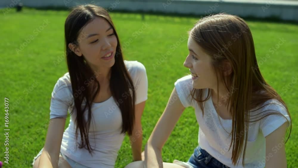 Close up of cheerful girls talking against nature background