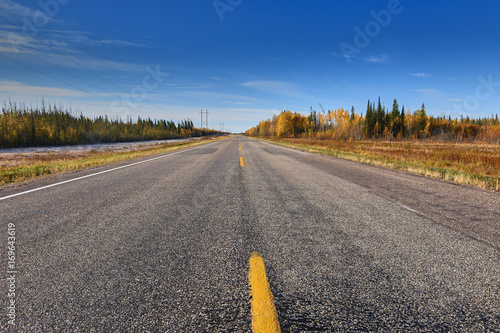 Highway in Northern Saskatchewan, Canada by Meadow Lake in Autumn. photo