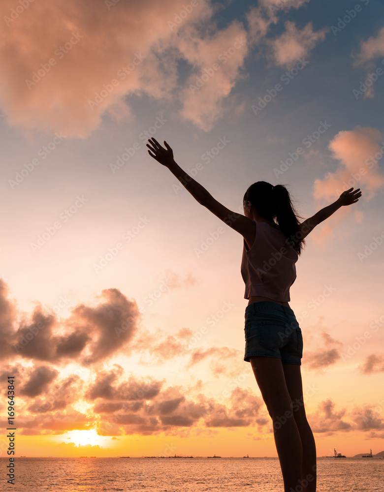 Silhouette of Woman open arm under sunset