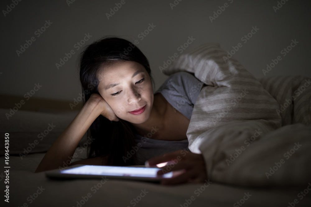 Woman using digital tablet computer at night Woman using digital tablet computer at night