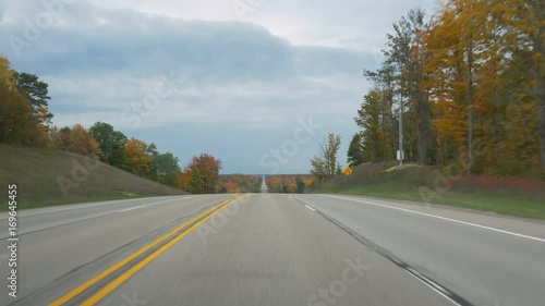 Driving POV on M-72 (Michigan state route 72) west of Grayling, in Kalkaska County, Michigan in autumn. photo