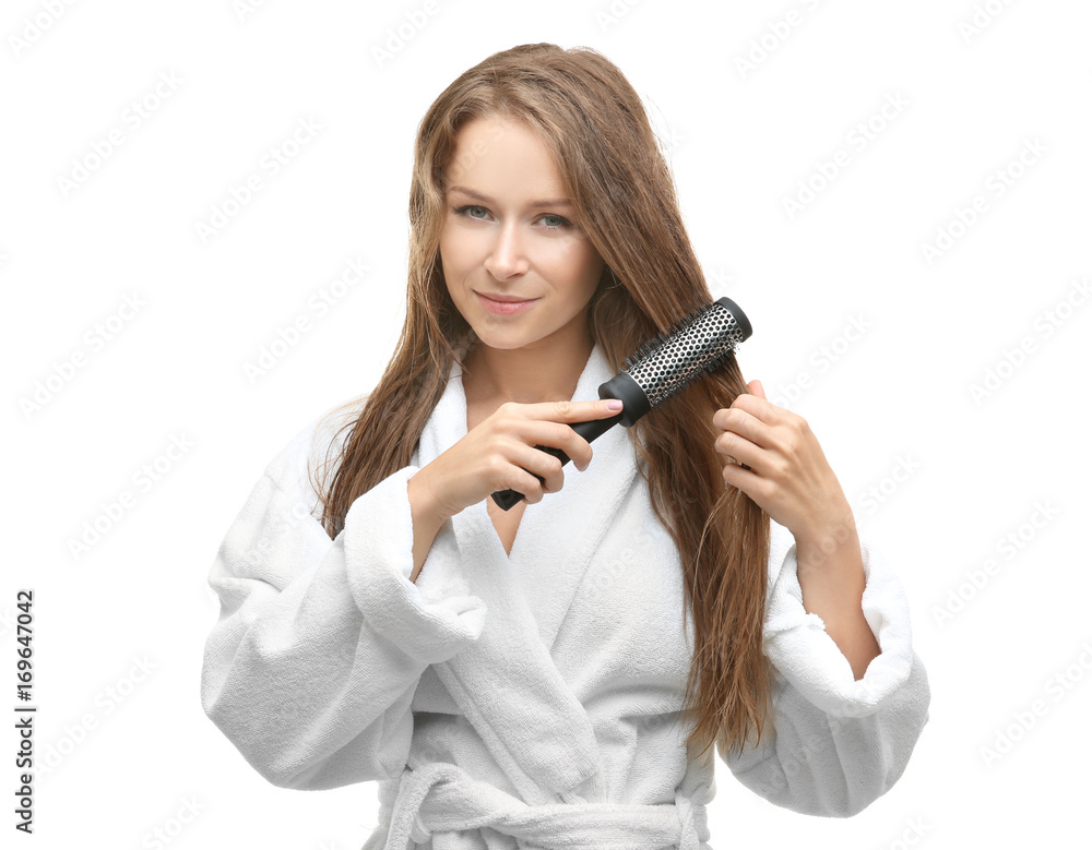 Beautiful young woman combing her hair after shower on white background Beautiful young woman combing her hair after shower on white background