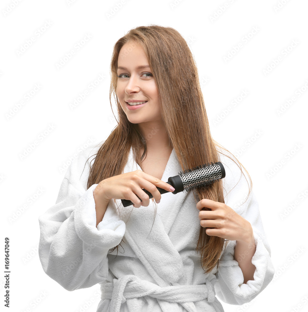 Beautiful young woman combing her hair after shower on white background Beautiful young woman combing her hair after shower on white background