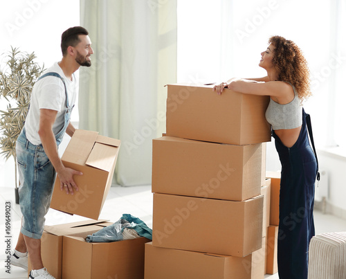 Young family unpacking boxes in a new house. © ASDF