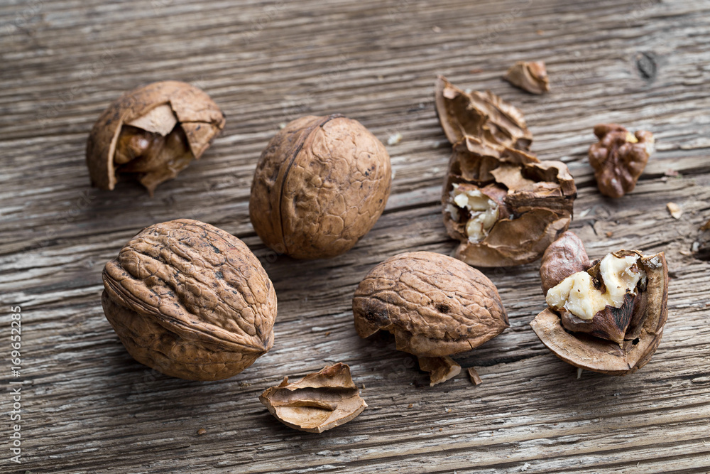Walnuts on a wooden aged rustic background. Broken, crushed walnuts Walnuts on a wooden aged rustic background. Broken, crushed walnuts