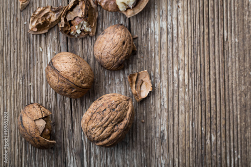 Walnuts on a wooden aged rustic background. Broken, crushed walnuts