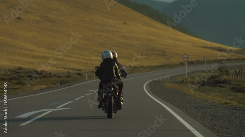 Couple of Motorcyclists on a Motorcycle are Driving along a Beautiful Country Road