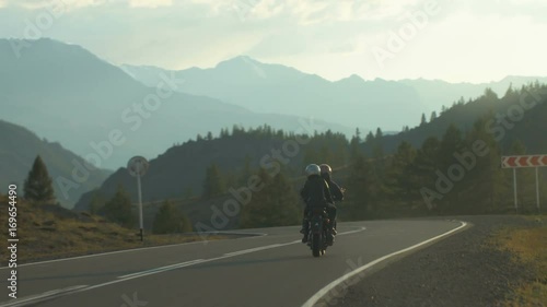 Couple of Motorcyclists on a Motorcycle are Driving along a Beautiful Country Road