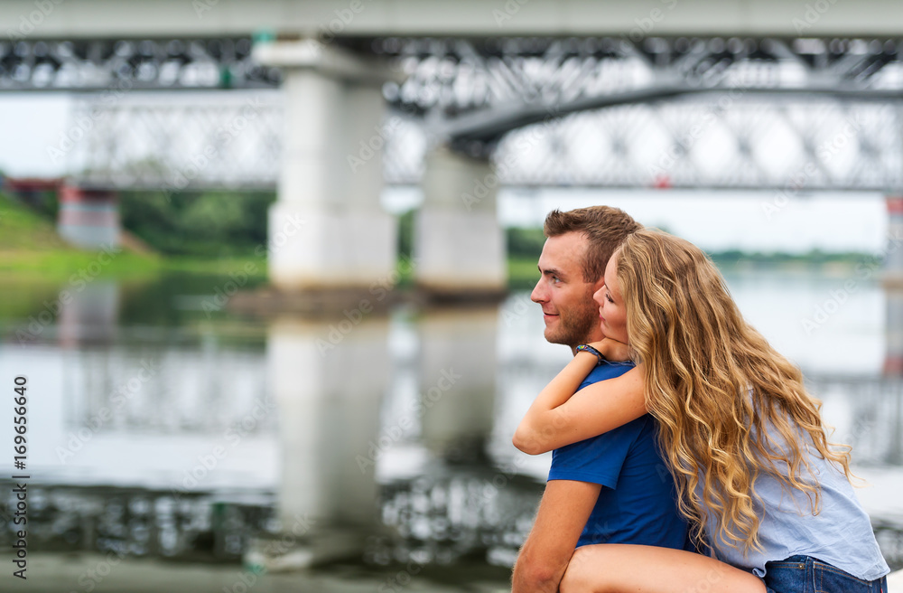 Happy romantic caucasian couple looking at a lake or river