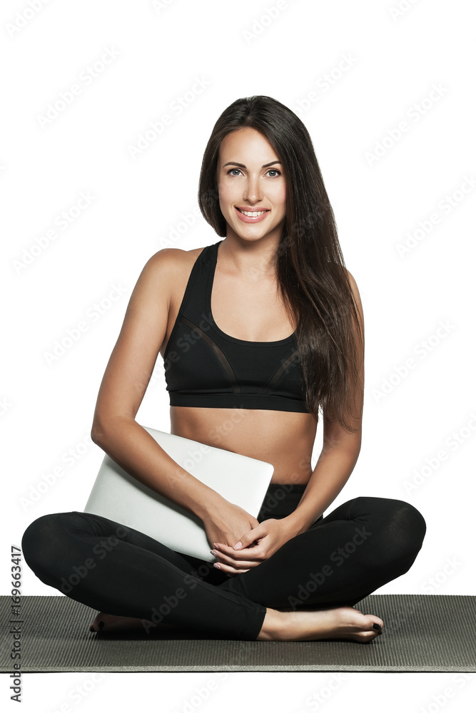 Young woman in sporty outfit holds her laptop Young woman in sporty outfit holds her laptop