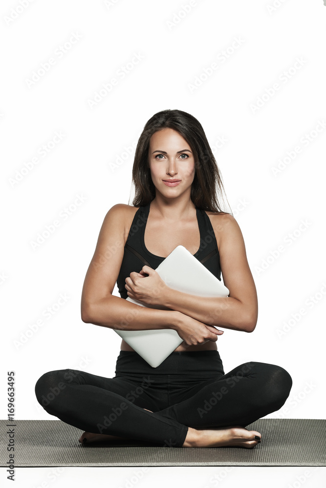 Young woman in sporty outfit holds her laptop