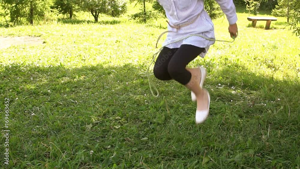Little girl learns to jump rope in the Park. Slow motion Little girl learns to jump rope in the Park. Slow motion