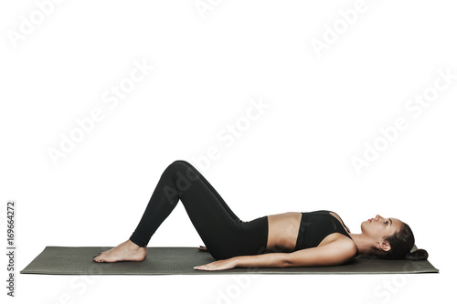 Woman exercising on yoga mat. Isolated on white. © denisovdmitry
