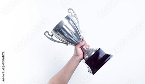 hand holding up a trophy cup as a winner in a competition