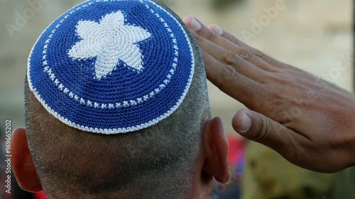 Israeli soldier military man saluting to the Western wall in Jerusalem. Western wall or Wailing wall or Kotel is the most sacred place for all jewish people.