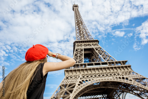 Young woman tourist in red cap looking on the Eiffel tower in Paris © rh2010