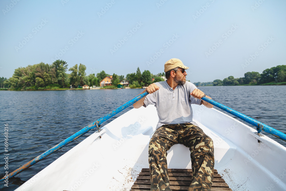 man with beard rowing on rowing boat