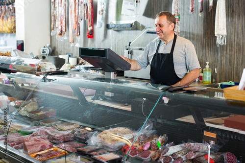 butcher with wurst at counter