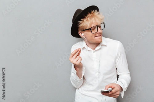 Cheerful caucasian man wearing glasses listening music