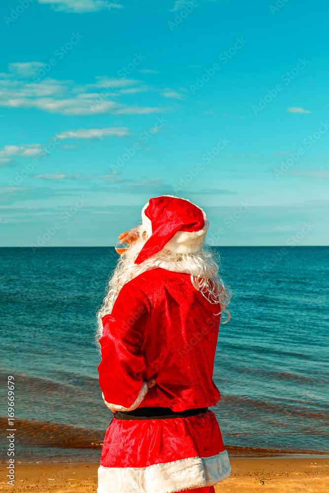 Obraz premium Santa Claus is standing on the beach.