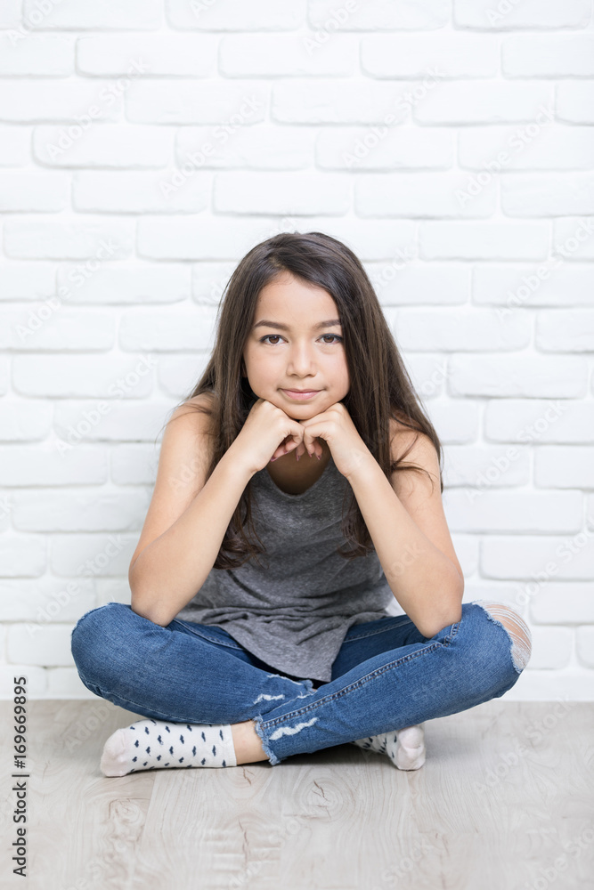 Portrait of a beautiful happy smiling girl sitting on the floor Portrait of a beautiful happy smiling girl sitting on the floor