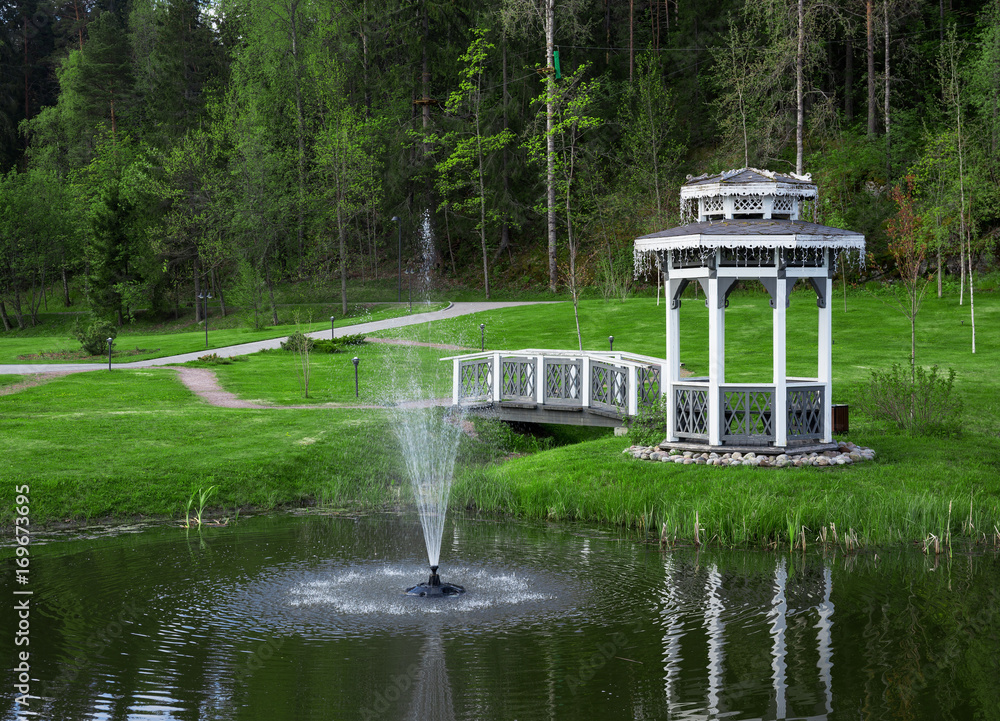Obraz premium Arbor with a bridge on a pond