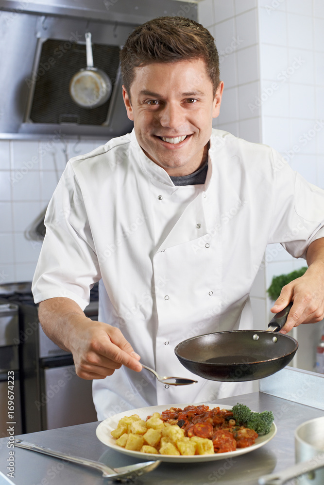 Chef Adding Sauce To Dish In Restaurant Kitchen Chef Adding Sauce To Dish In Restaurant Kitchen