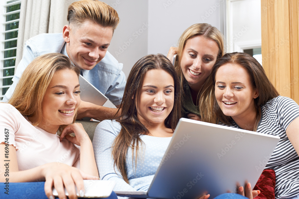 Group Of Teenagers Using Digital Technology At Home