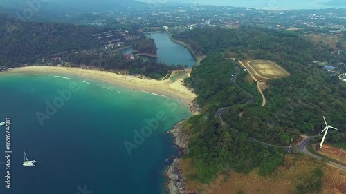 Aerial. Silent tropical beach, flying close above a tropical sandy beach and waves, beautiful view from the air shot over an Indian ocean deserted beach. Blue sea, sky, white clouds.