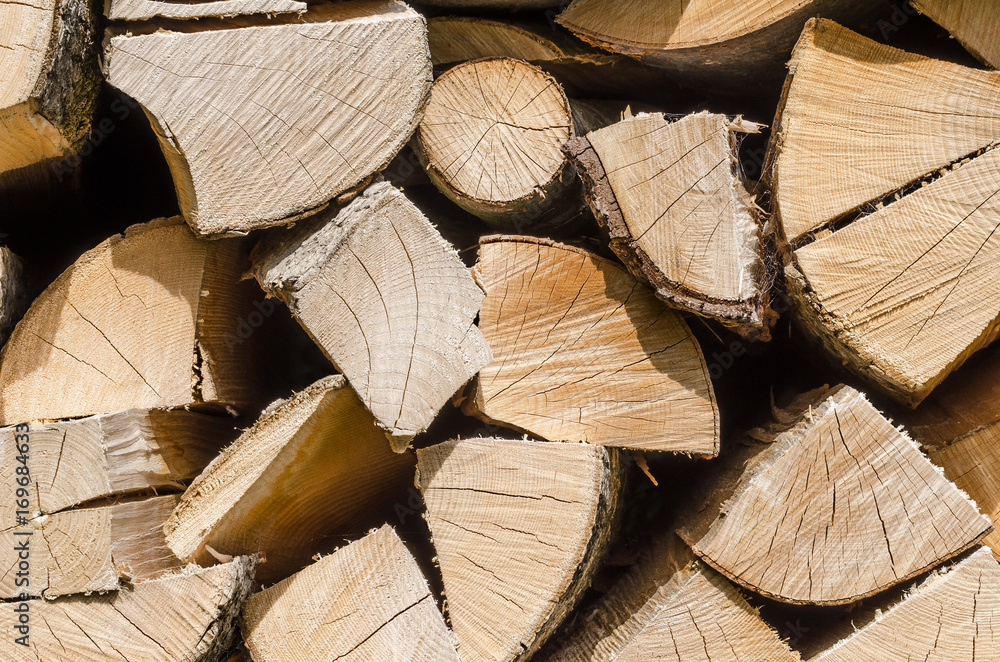 Splitted, dried and stacked firewood, horizontal front view. Stack of weathered, dry wood, a source of energy. Front view. Photo. Splitted, dried and stacked firewood, horizontal front view. Stack of weathered, dry wood, a source of energy. Front view. Photo.