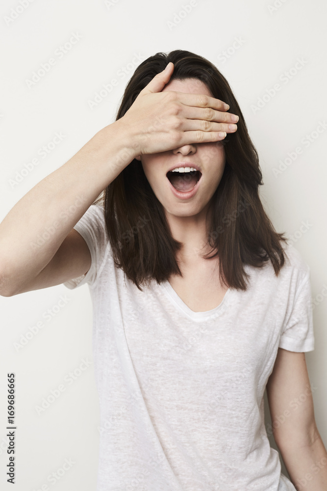 Brunette babe shielding eyes and looking shocked, studio Brunette babe shielding eyes and looking shocked, studio