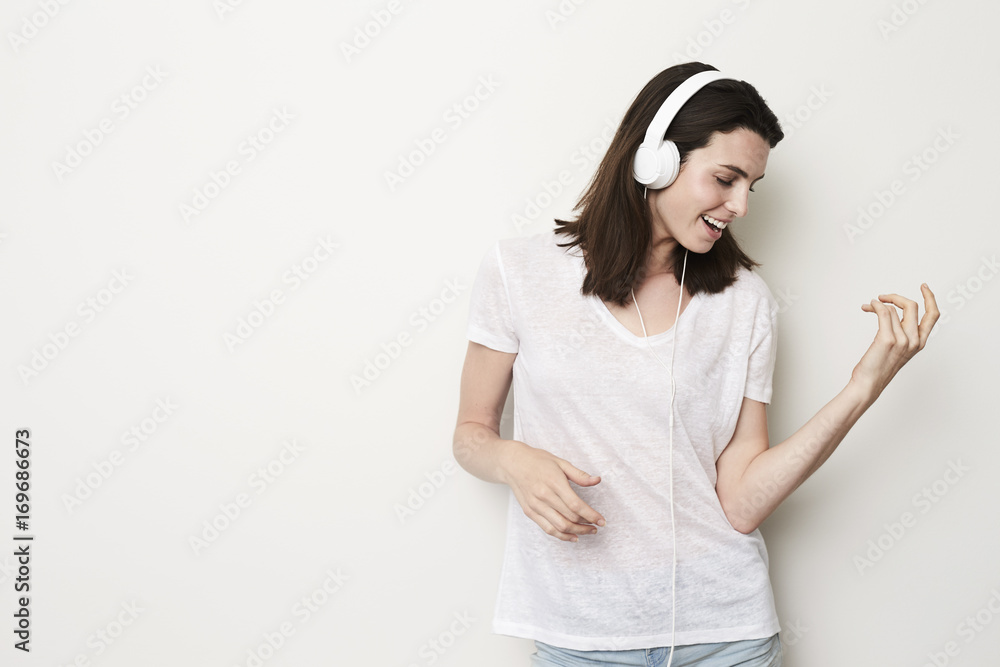 Air guitar girl playing to headphones in studio Air guitar girl playing to headphones in studio