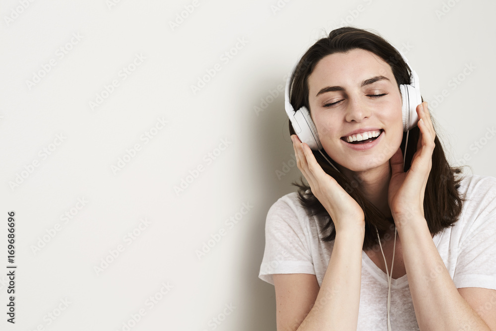 Beautiful young woman lost in music from headphones Beautiful young woman lost in music from headphones