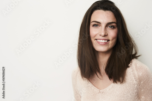 Young brunette with beautiful smile in studio