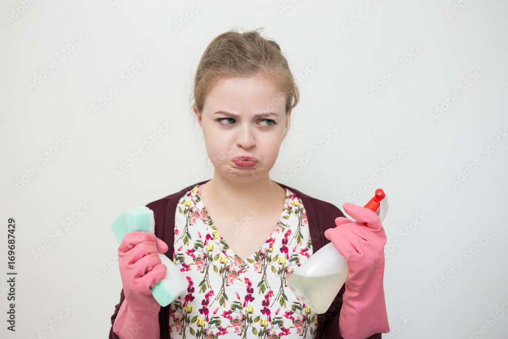Caucasian girl with sponge and sprayer, upset, sad Caucasian girl with sponge and sprayer, upset, sad