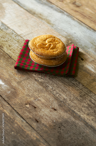 Duo of delicious basque cake put on a fabric with tile and wooden boards.