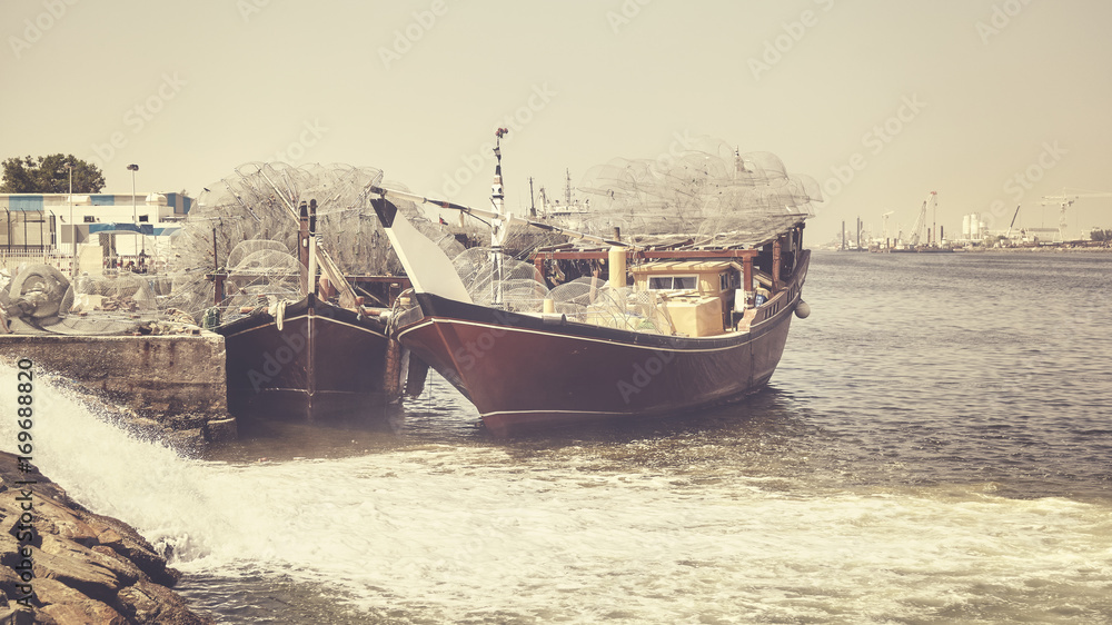 Fishing boats in Ajman harbor, color toning applied, United Arab Emirates.