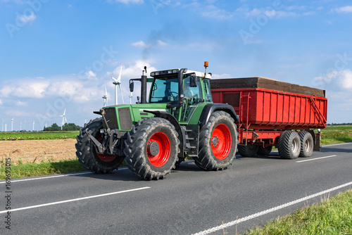 Tractor with loading trailer on the country road - 6942