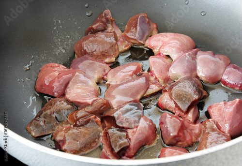 Pieces of raw beef liver in frying pan